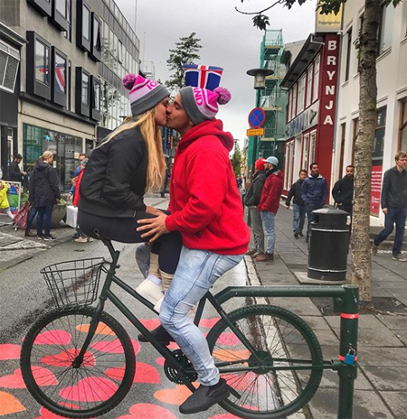 Vitaly and Kinsey kiss on a stationary bike in Iceland.